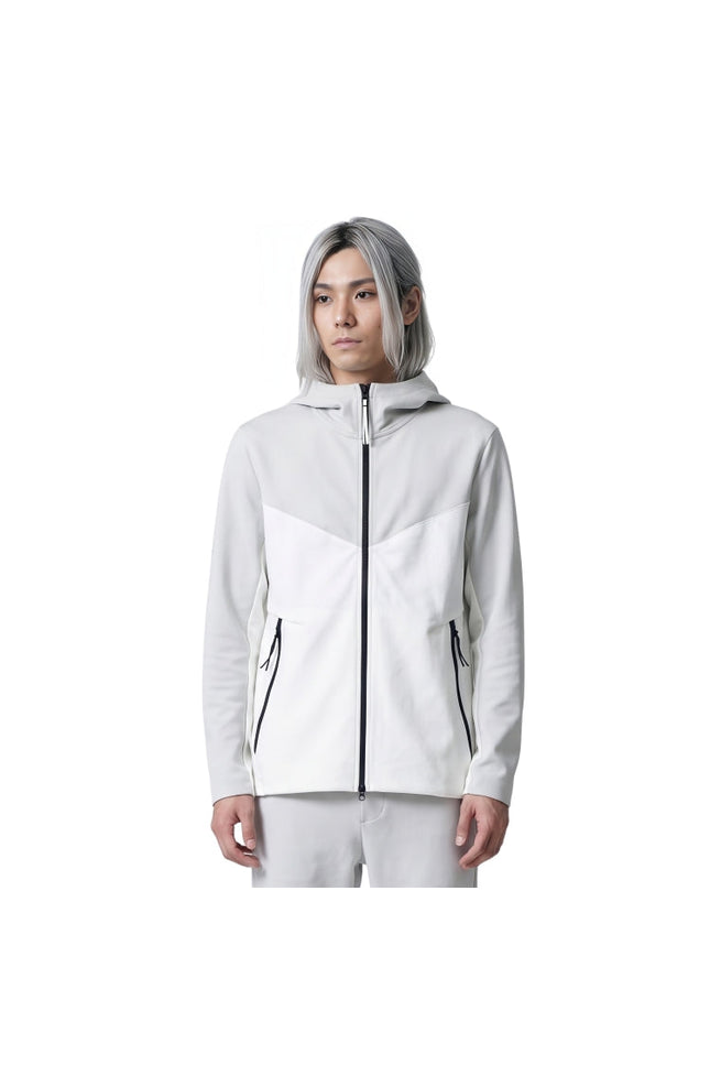 Person wearing a white jacket with black zippers on a white background