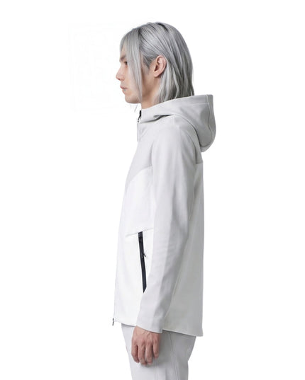 Person wearing a white hooded jacket on a white background