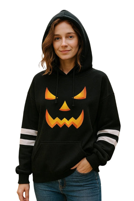 Person wearing a black hoodie with a jack-o'-lantern face design on a white background
