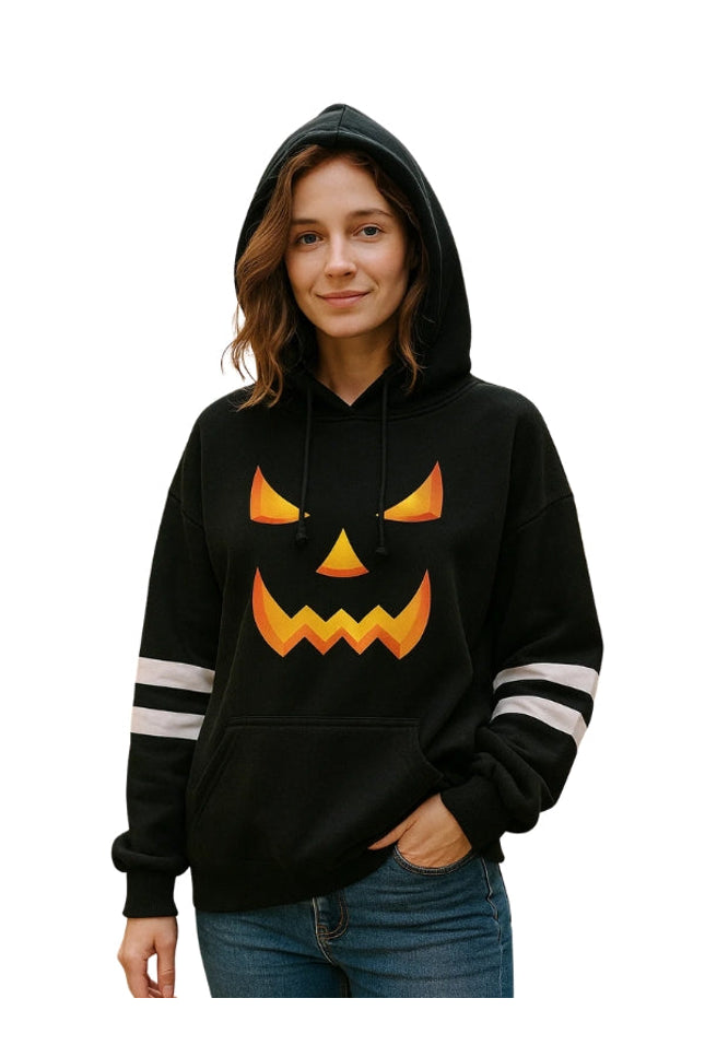 Person wearing a black hoodie with a jack-o'-lantern face design on a white background