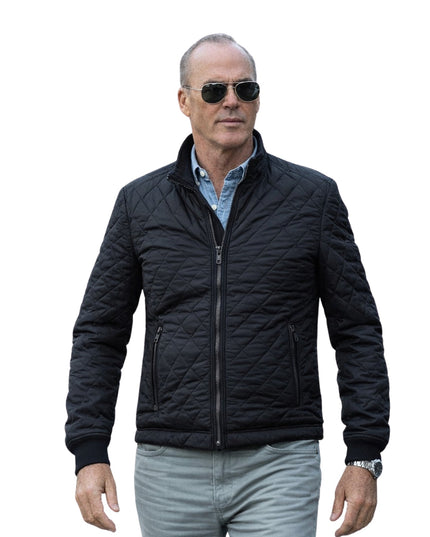 Man wearing a black quilted jacket and sunglasses on a white background