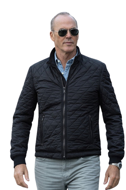 Man wearing a black quilted jacket and sunglasses on a white background