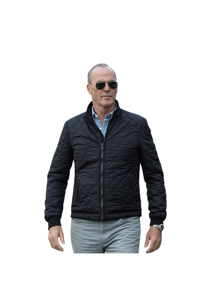 Man wearing a black quilted jacket and sunglasses on a white background
