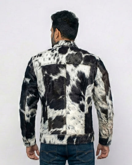 Person wearing a black and white cowhide leather jacket on a white background