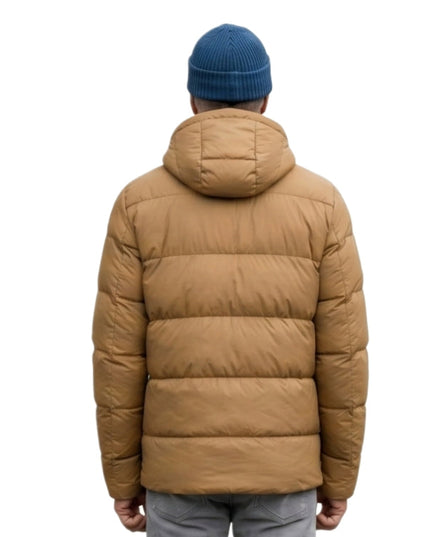 Person wearing a brown puffer jacket and blue beanie on a white background