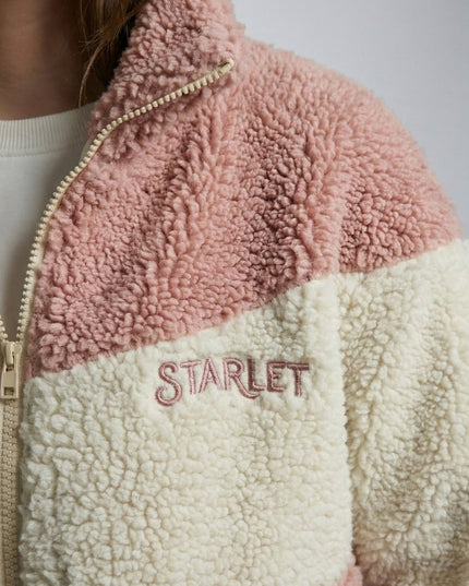 Close-up of a pink and beige sherpa jacket with 'STARLET' branding.