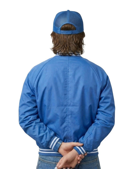 Person wearing a blue jacket and cap from behind on a white background