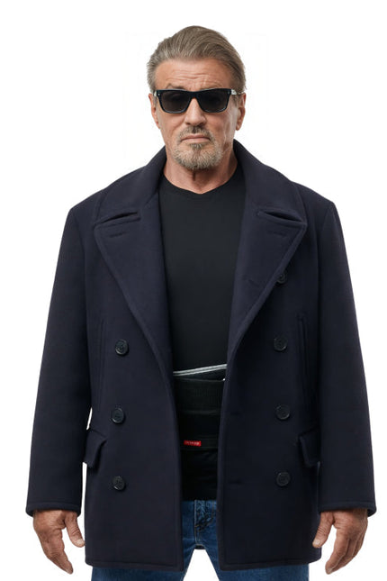 Man wearing a dark coat, black shirt, and sunglasses on a white background