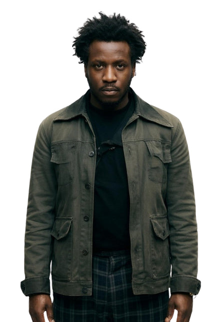 Man wearing a dark green jacket over a black shirt on a white background