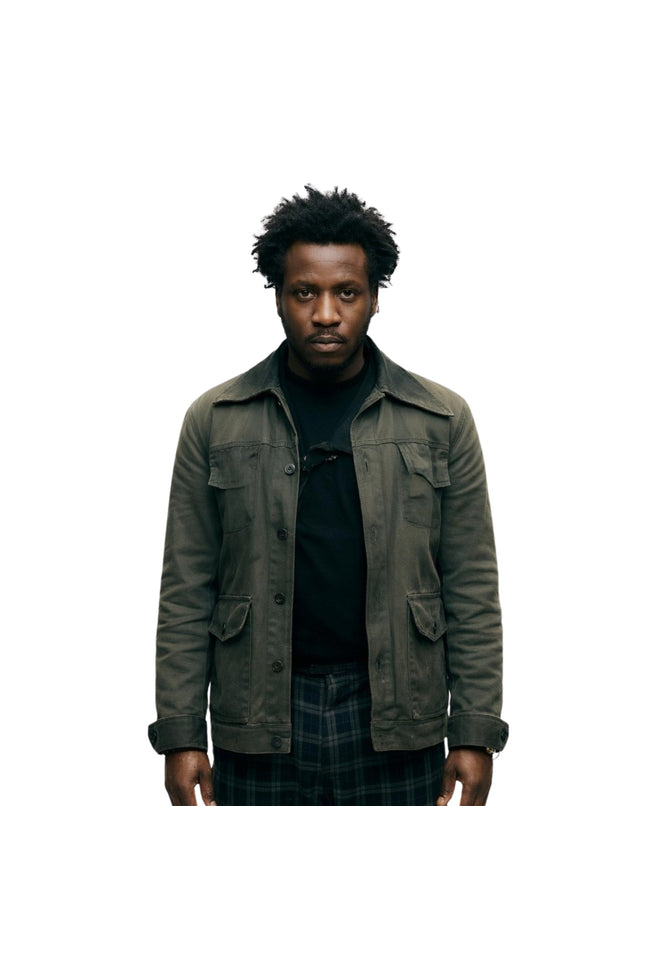 Man wearing a dark green jacket over a black shirt on a white background