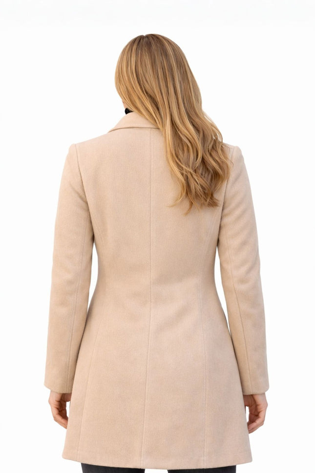 Woman wearing a beige coat on a white background