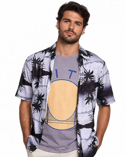 Man wearing a patterned shirt over a graphic t-shirt on a white background