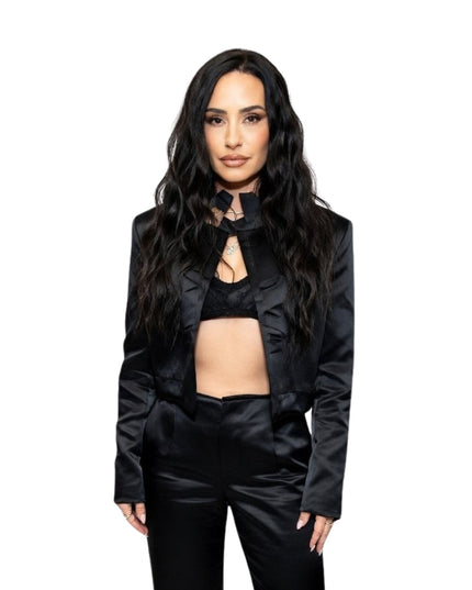 Woman wearing a black outfit with ruffled details on a white background