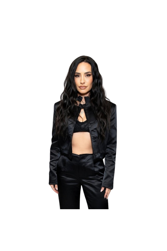 Woman wearing a black outfit with ruffled details on a white background