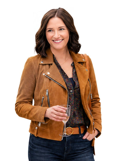 Woman wearing a brown leather jacket holding a glass of wine on a white background
