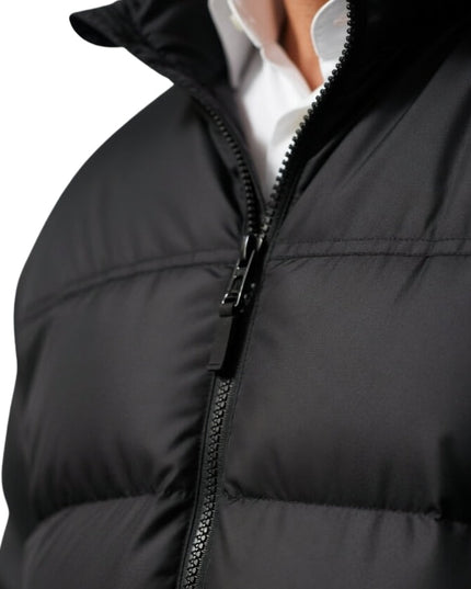 Close-up of a black puffer jacket with a white shirt underneath on a white background
