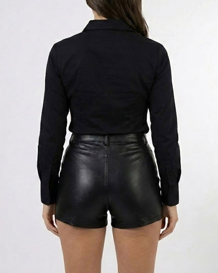 Person wearing a black long-sleeve shirt and black leather shorts on a white background