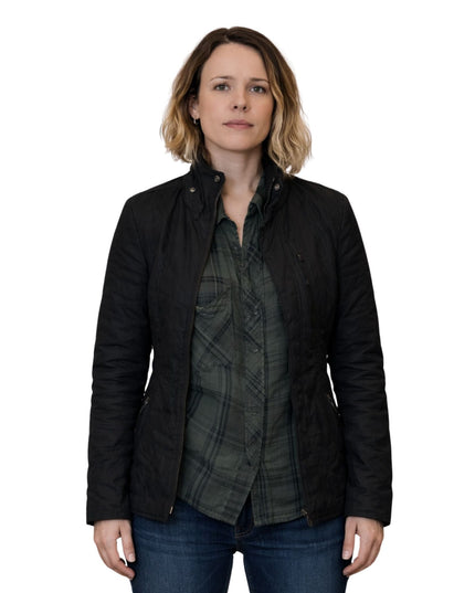 Woman wearing a black jacket over a plaid shirt on a white background