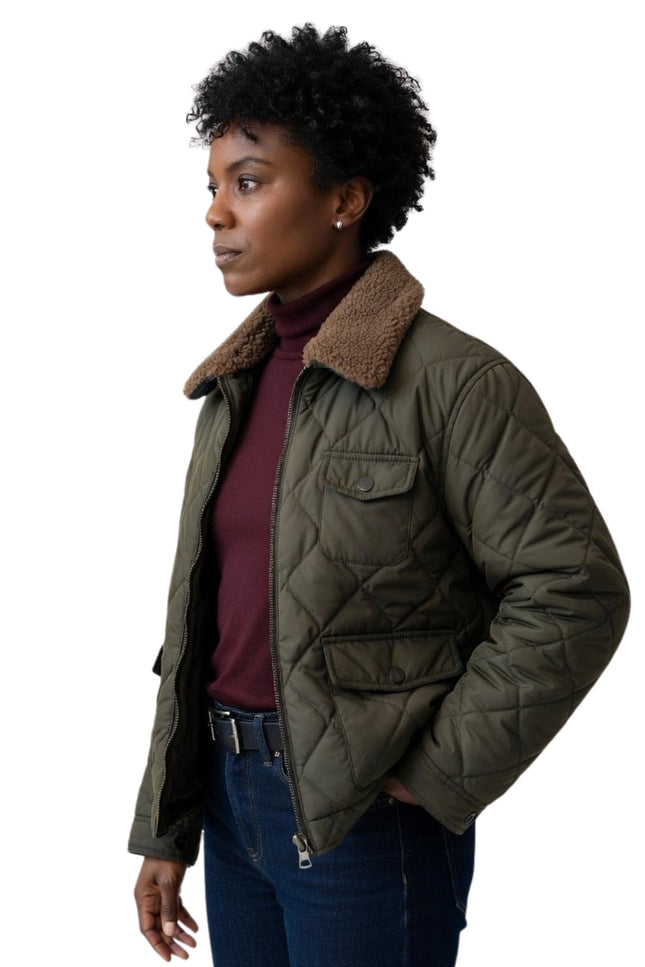 Woman wearing a green quilted jacket with a fur-lined hood on a white background