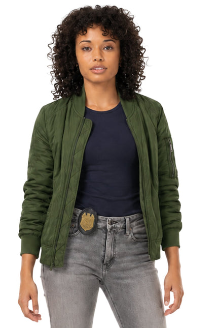 Woman wearing a green jacket, black shirt, and gray jeans on a white background