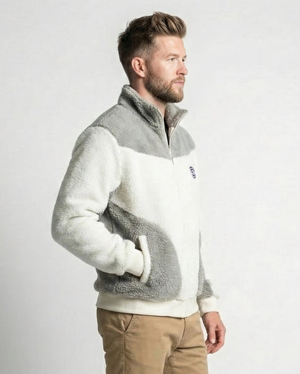 Man wearing a gray and white fleece jacket with a visible brand logo on a light gray background