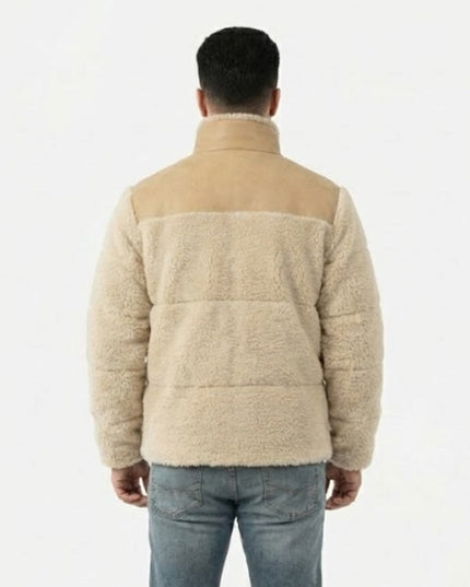 Person wearing a beige quilted jacket on a white background