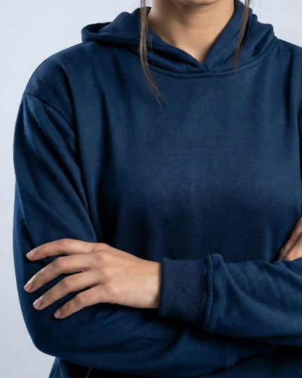 Person wearing a navy blue hoodie against a light gray background