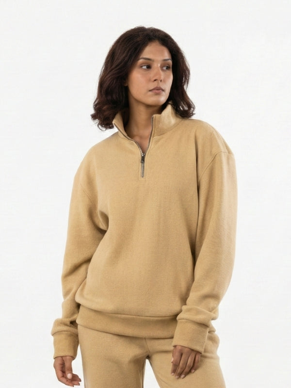 Woman wearing a beige tracksuit on a white background