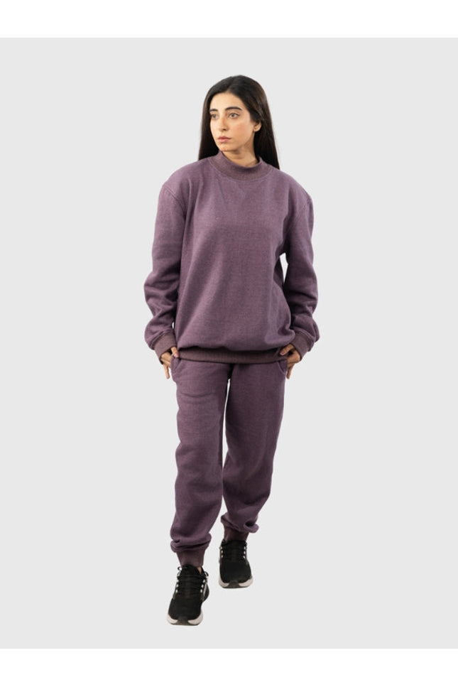 Person wearing a purple sweatshirt and pants set on a white background