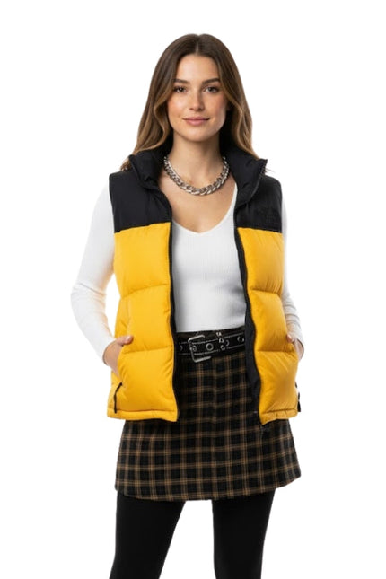 Woman wearing a yellow and black puffer vest on a white background