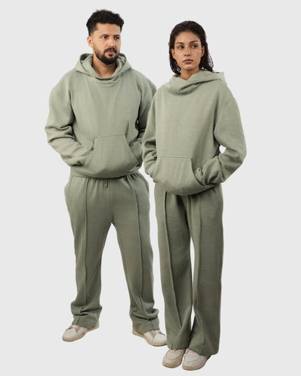 Two people wearing matching olive green hoodies and pants on a white background