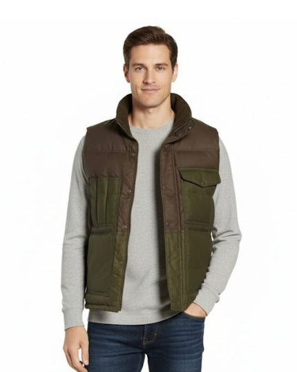 Man wearing a brown and green vest over a gray sweater on a white background