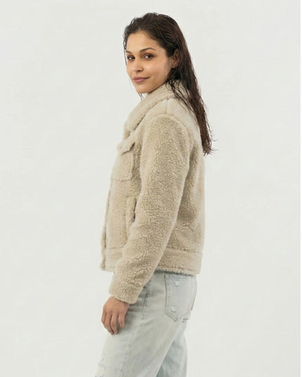 Woman wearing a beige sherpa jacket on a white background