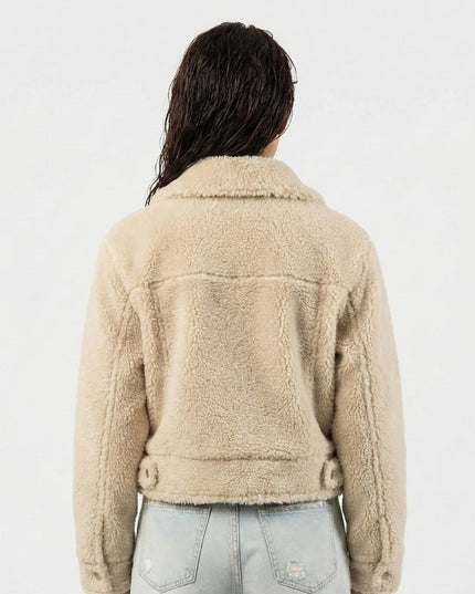 Person wearing a beige sherpa jacket on a white background