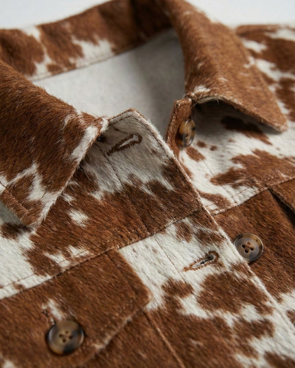 Close-up of a brown and white cowhide jacket with buttons.