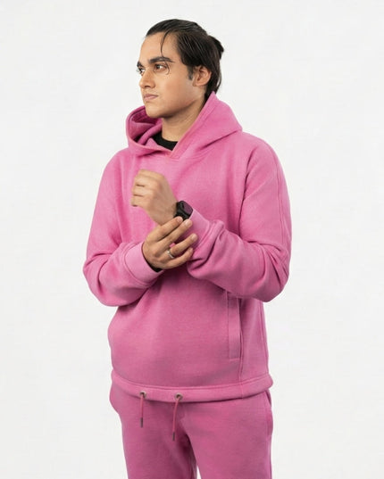 Person wearing a pink hoodie and pants on a white background