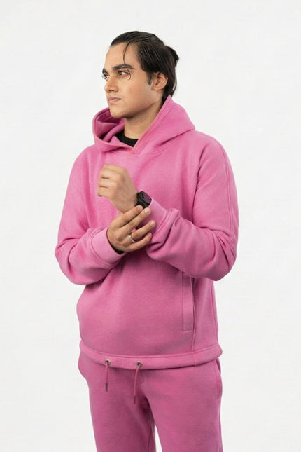 Person wearing a pink hoodie and pants on a white background