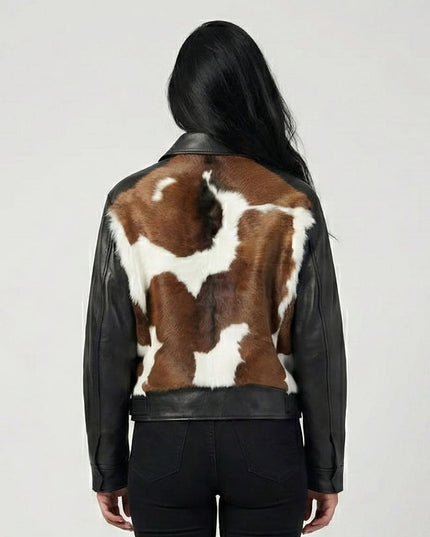 Person wearing a black leather jacket with a cowhide pattern on the back against a white background