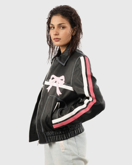 Woman wearing a black jacket with pink and white accents on a light gray background