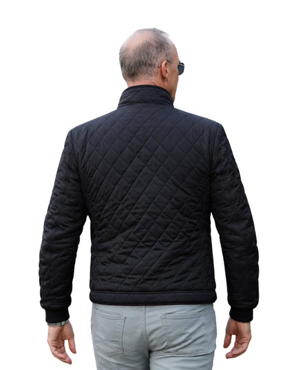 Man wearing a black quilted jacket on a white background