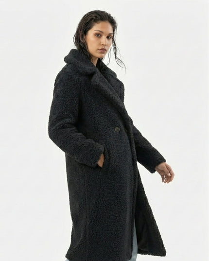 Woman wearing a black coat on a white background