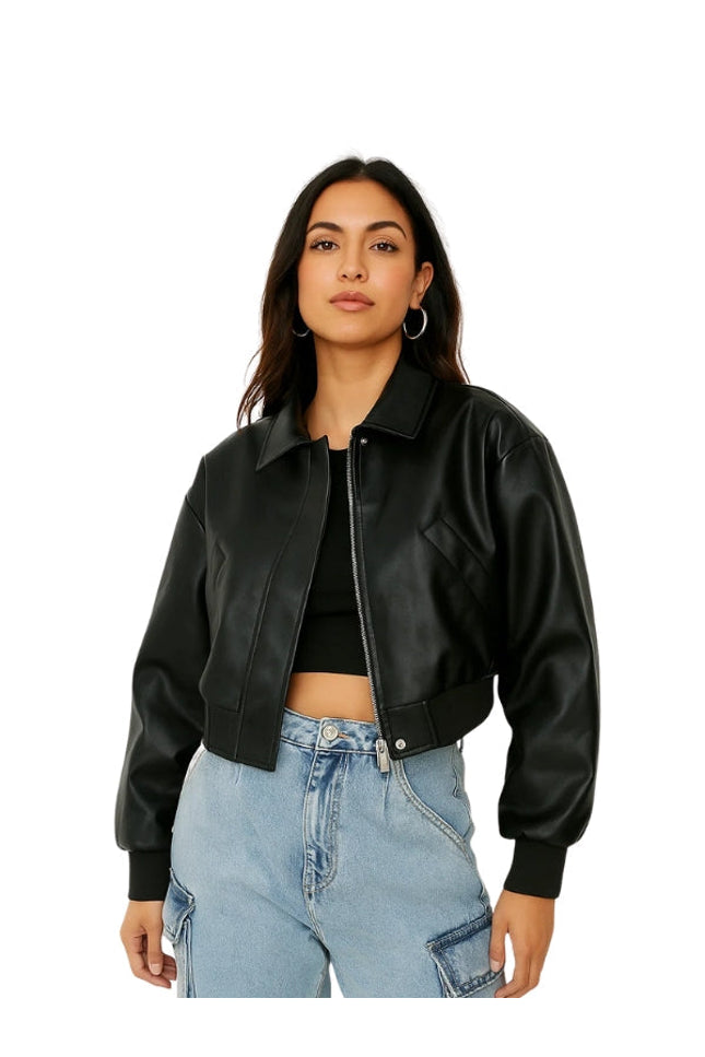 Woman wearing a black leather jacket and blue jeans on a white background