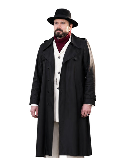 Man wearing a long black coat, hat, and red sweater on a white background
