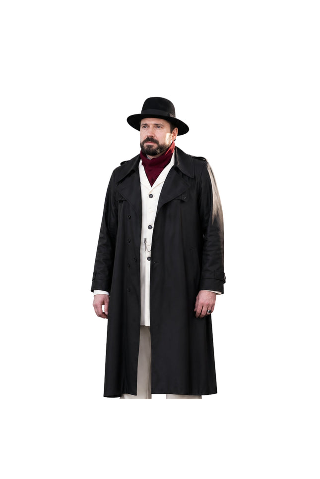 Man wearing a long black coat, hat, and red sweater on a white background