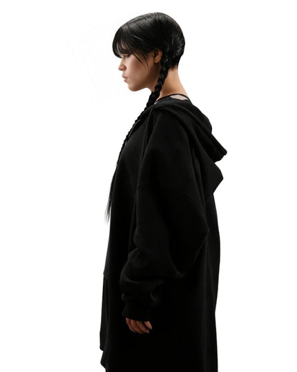 Person wearing a black hooded outfit on a white background