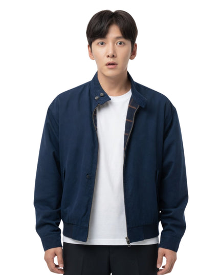 Man wearing a navy blue jacket over a white shirt on a white background