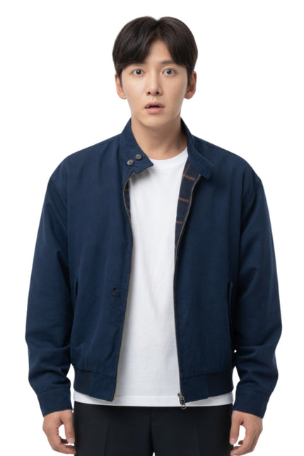 Man wearing a navy blue jacket over a white shirt on a white background