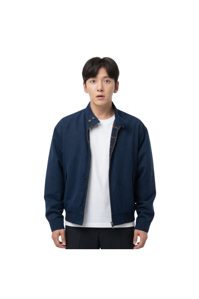 Man wearing a navy blue jacket over a white shirt on a white background