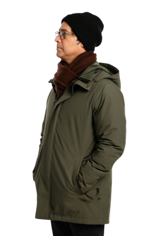 Man wearing a green parka, black beanie, and brown scarf on a white background