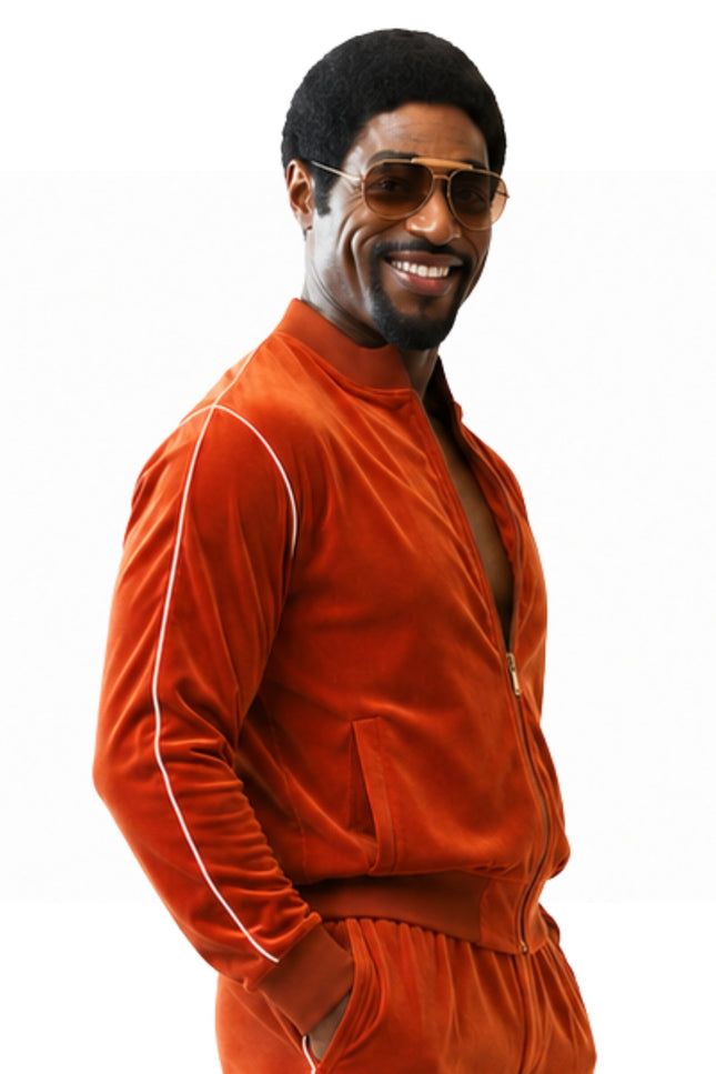 Man wearing an orange tracksuit and sunglasses on a white background